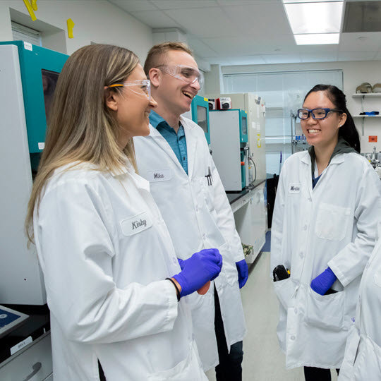 Four lab-coated professionals share ideas, emphasizing Teva's commitment to improving health daily.