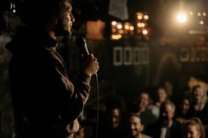 Young caregiver performing stand-up comedy as his new passion