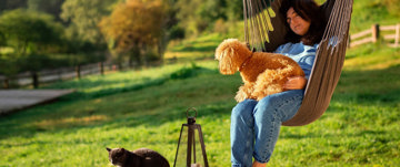 Woman in hammock chair interacting with her pets for a natural mood-boost