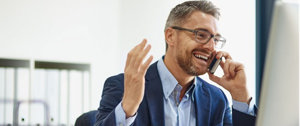 Happy businessman with cystic fibrosis talks with his clients over the phone.