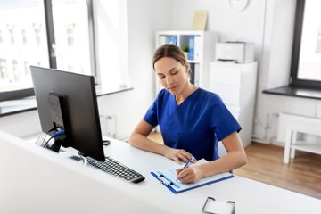 Nurse taking notes at computer for her postgraduate degree