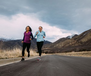 Two friends running a virtual marathon in the countryside. 