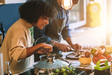 Woman cooking on the stove, making a heart-healthy dinner with her partner