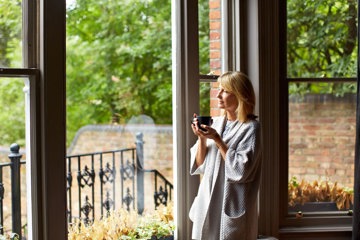 Woman drinking coffee by the window 