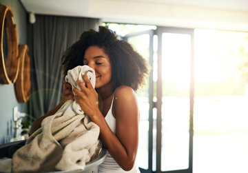 Woman enjoys smell of freshly washed clothes.