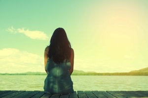 Woman reflecting on mental health troubles as she looks out to sea