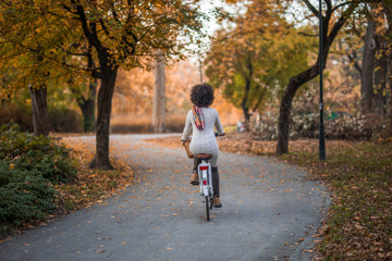 Woman with asthma riding a bike on an autumn road.