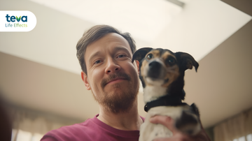 Man hugging a dog and smiling