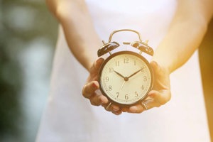 Woman with ADHD holding a clock in both hands for guidance